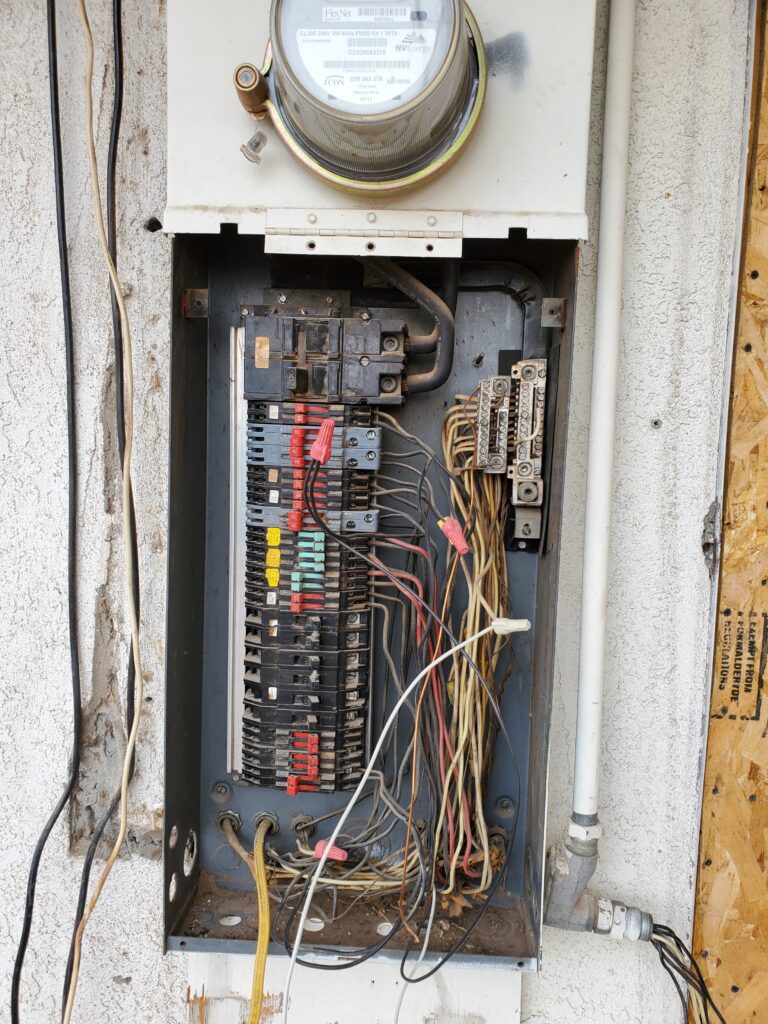 Open residential electrical panel showing rows of circuit breakers and wiring