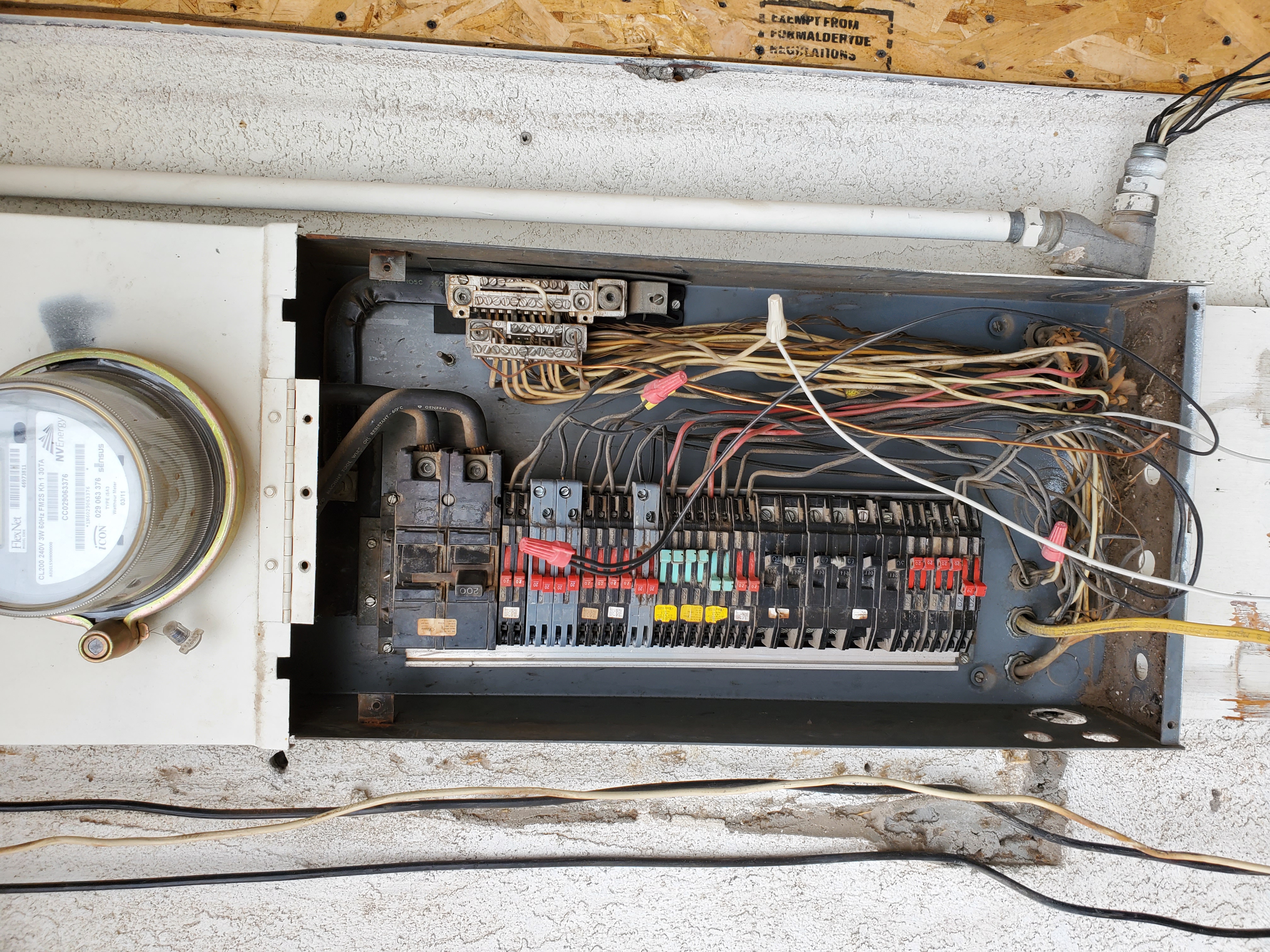 Open residential electrical panel showing rows of circuit breakers and wiring